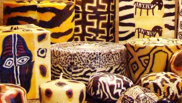 Several blocks and rounds of cheese are decorated with intricate, colorful patterns resembling animal prints and abstract designs, including stripes, spots, and geometric shapes.