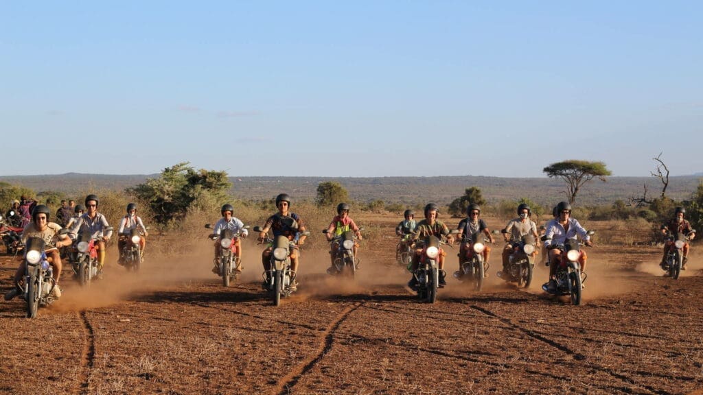 groep reizigers rijdt met motoren over stoffige savanne tijdens avontuurlijke tocht in kenia
