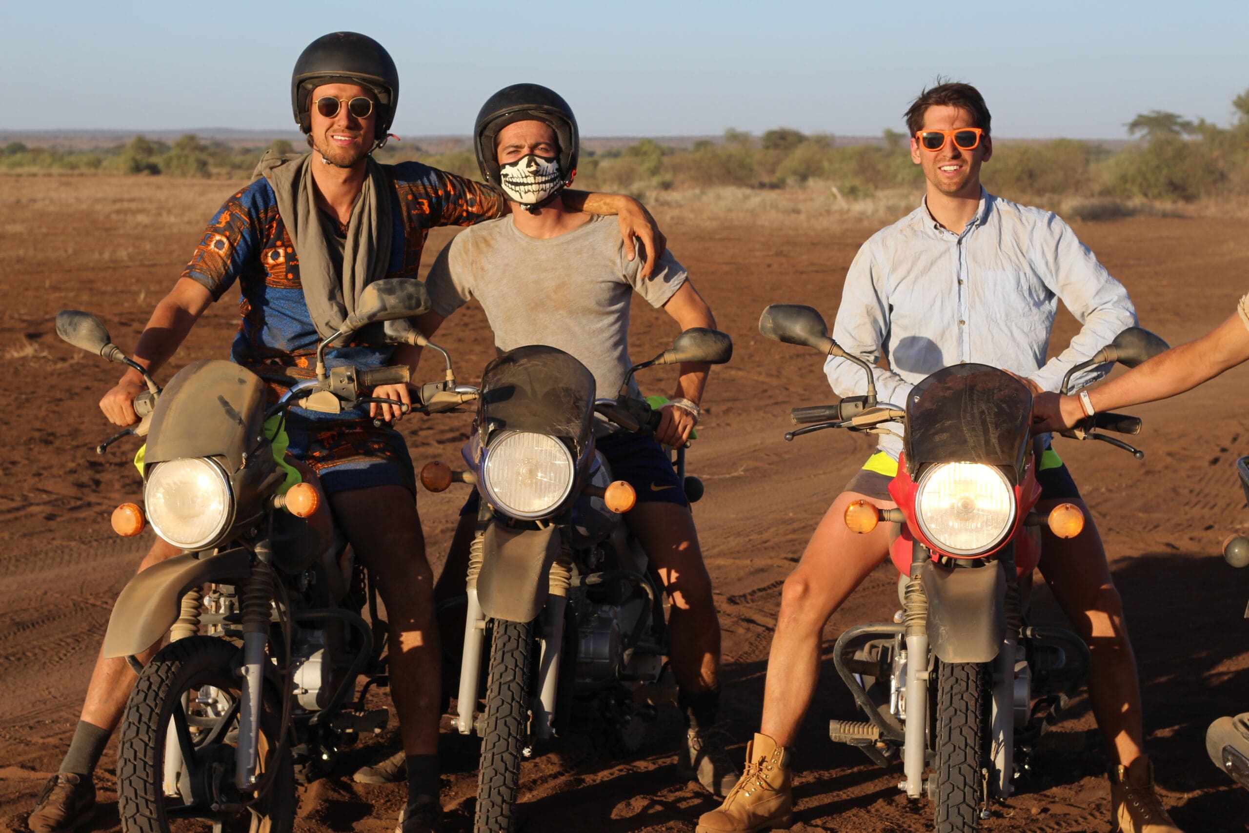 twee vrienden met helm op motorfietsen in droog landschap in kenia